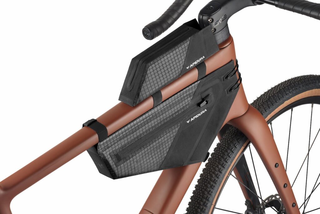 Apidura Aero System S/M completamente instalado sobre bicicleta gravel color cobre, mostrando su perfil aerodinámico funcional.