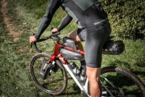 Ciclista pedaleando por sendero con bicicleta equipada con bolsa de sillín GIVI Gateway