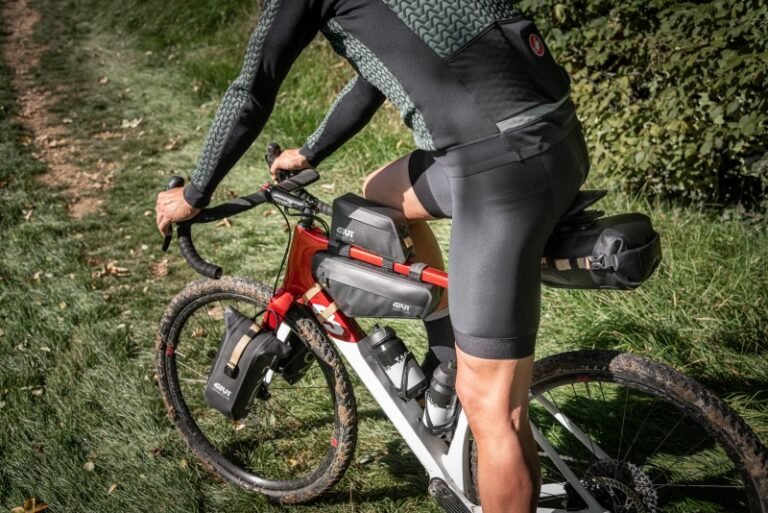 Ciclista pedaleando por sendero con bicicleta equipada con bolsa de sillín GIVI Gateway