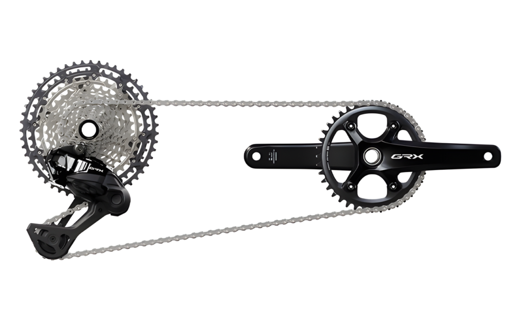Transmisión Shimano GRX Di2 827 de 12 velocidades, que incluye un desviador trasero electrónico, cassette de amplio rango, cadena y bielas con un solo plato delantero. El brazo de la biela lleva el logo GRX en blanco, y el sistema está diseñado específicamente para gravel, con cambios electrónicos precisos y compatibilidad con configuraciones 1x12.