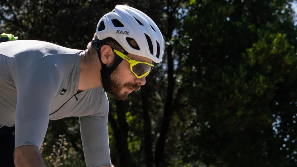 Ciclista con casco Kask Mojito blanco pedaleando en ruta gravel