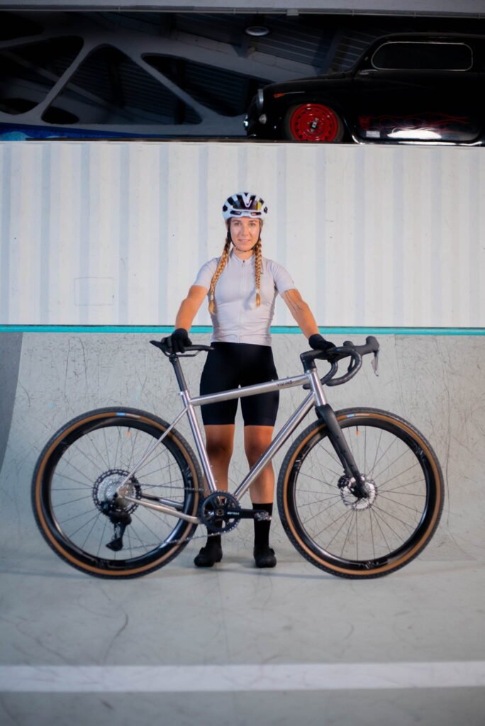 Ciclista posando con la bicicleta gravel VIKING Cykles Valhalla GR 2 en una pista de skatepark, vista lateral completa del cuadro de titanio